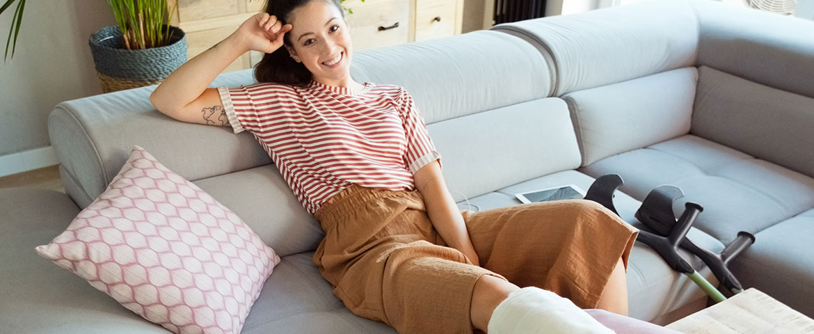 Jeune femme avec le pied dans le plâtre