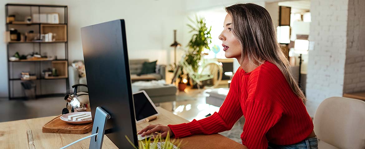 Une femme qui consulte son ordinateur dans son salon 
