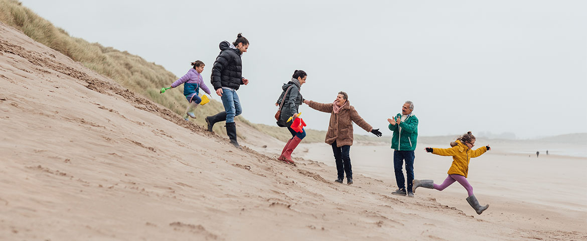 Une famille qui s'amuse dans une dune de sable 