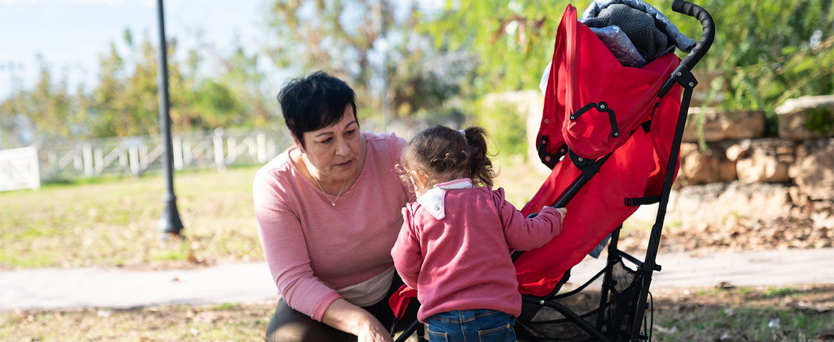 Une nounou qui parle avec l'enfant qu'elle garde dans un parc