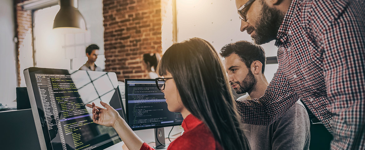 Plusieurs personnes regardant le même ordinateur dans un open space