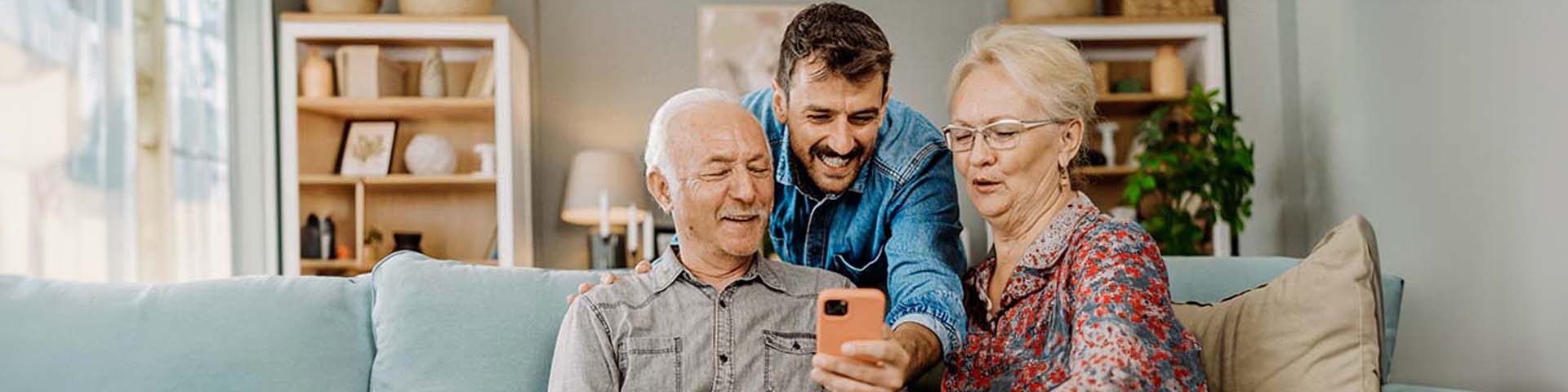 Un homme qui montre quelque chose sur son téléphone à ses parents