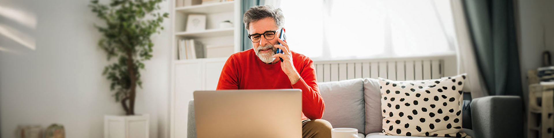 Un homme au téléphone qui consulte son ordinateur 