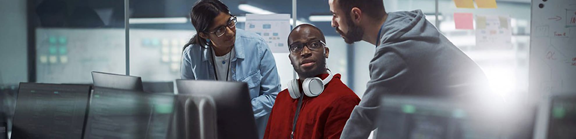 trois collaborateurs discutant autout d'un ordinateur