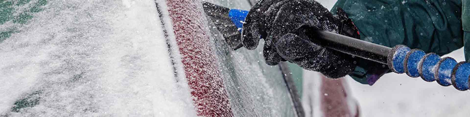 une personne dégèle son pare-brise