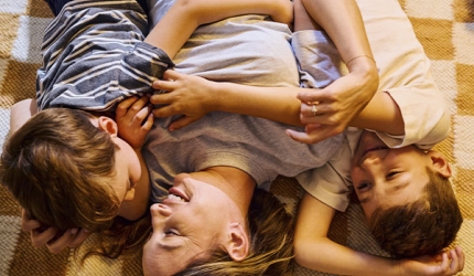 Une mère et ses deux fils sur un tapis