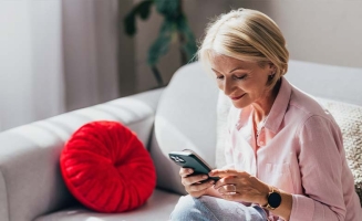 Une femme sur son canapé regardant son téléphone