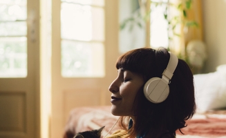 une femme qui écoute de la musique dans son salon avec un chat