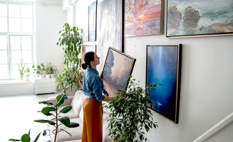 une femme qui accroche des tableaux