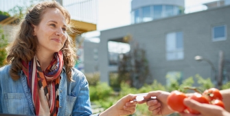 Dame qui achète des tomates en direct producteur