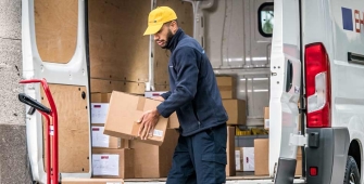 Livreur qui sort de la marchandise de son camion