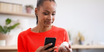 Une femme se renseignant sur ses médicaments à l'aide de son téléphone