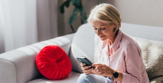 Une femme sur son canapé regardant son téléphone