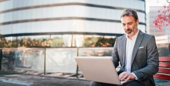un homme devant un entreprise avec son ordinateur