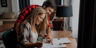 Un couple est assis dans son salon, en train de consulter son contrat