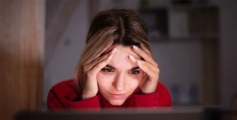 Une femme préoccupée devant son ordinateur