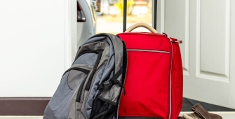 Des valises préparées devant la porte d'une maison