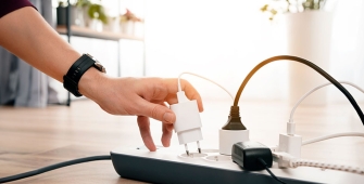 Quelqu'un qui débranche un chargeur d'une multiprises