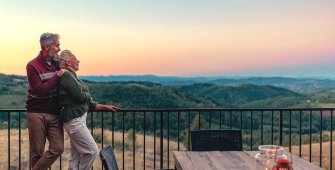 Un couple sur une terrasse regardant un couché de soleil
