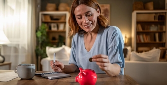 Une femme met une pièce dans une tirelire
