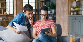 un couple dans un salon l'air préoccupé