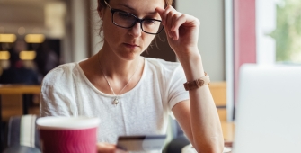 une femme devant un ordinateur dans un café