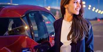 une femme est devant son véhicule