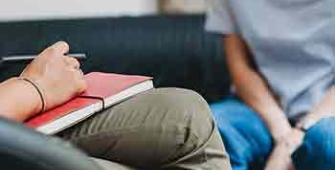 un jeune est assis sur le canapé devant un psychologue