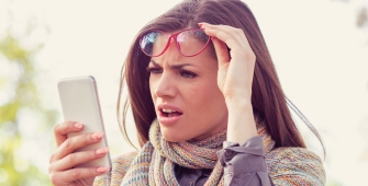 une femme regardant son téléphone suprise