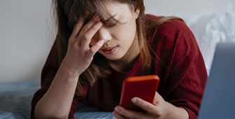 femme qui semble en détresse son smartphone en main