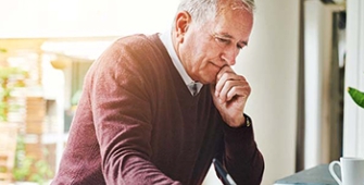 senior assis face à son ordinateur