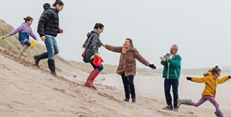 famille dévalant une dune de sable