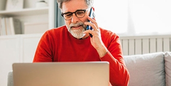 homme au téléphone face à son ordi