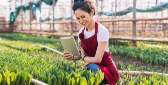Une agricultrice avec sa tablette numérique dans une serre