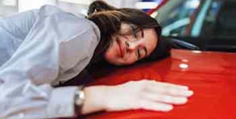 une femme fait un calin à sa voiture