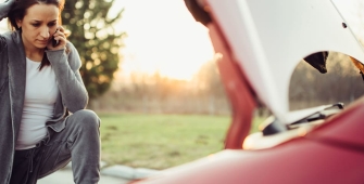 Une femme devant sa voiture après un accident 