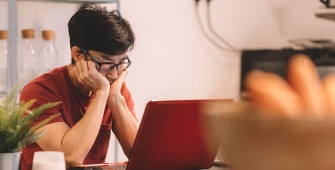 Un homme stressé regarde son ordinateur