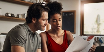 Un couple entrain de lire un papier dans leur cuisine 