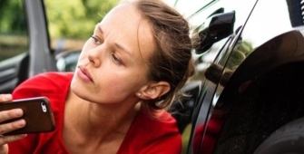 femme faisant un constat près de sa voiture