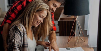 couple inspectant des documents posés sur un bureau
