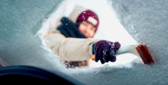 Une femme qui déneige son parebrise 
