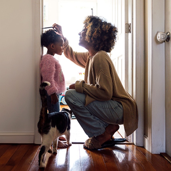 une mère et sa fille dans un logement avec un chat qui passe
