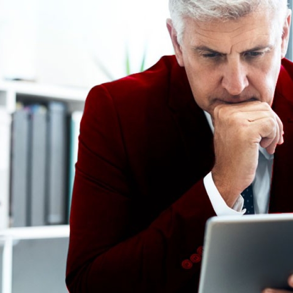 Un homme en costume qui consulte sa tablette