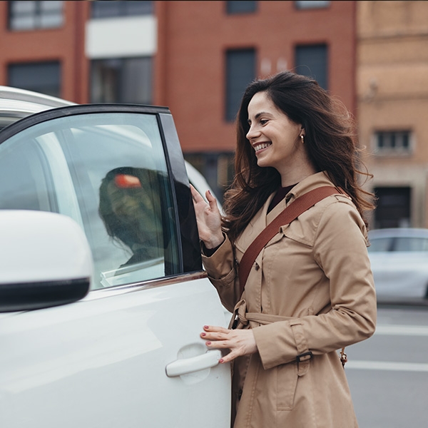 une femme qui rentre dans sa voiture de ville