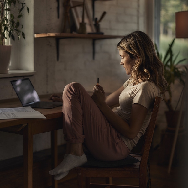 une femme chez elle devant son ordinateur