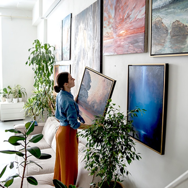 une femme qui accroche des tableaux
