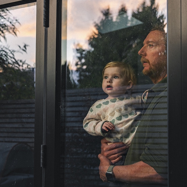 Un homme qui porte son fils et regardent par la fenêtre