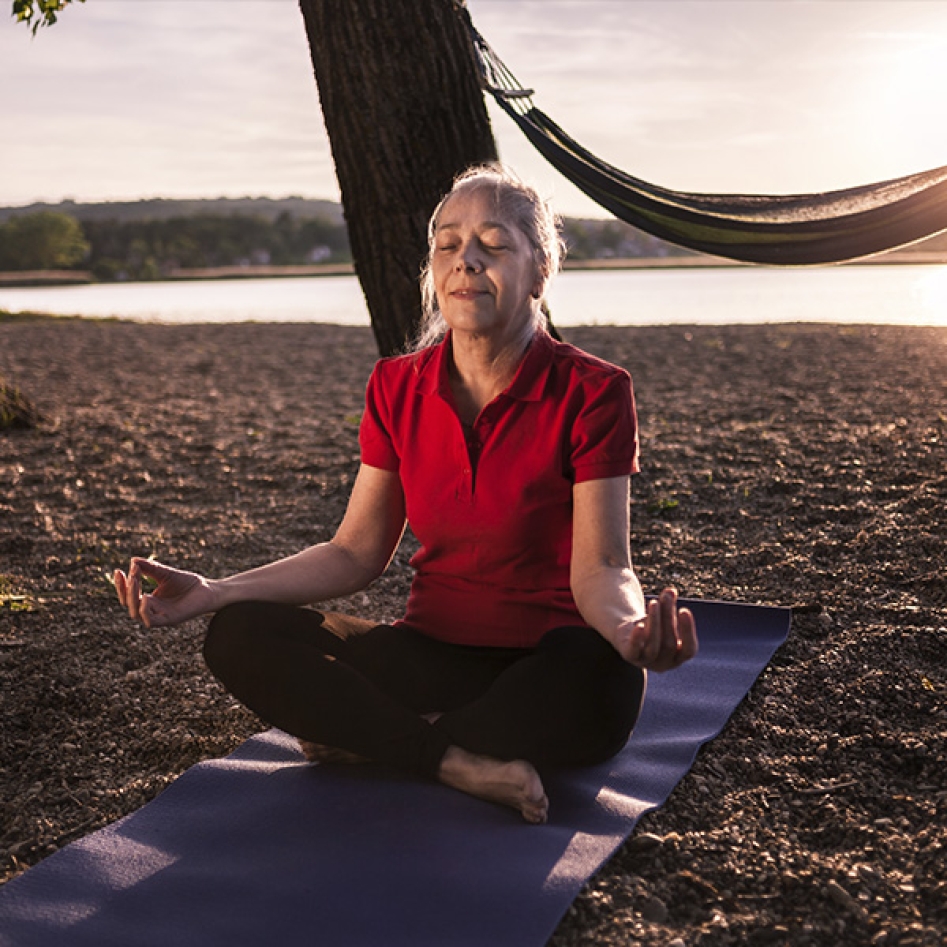 une femme qui fait du yoga sur la plage